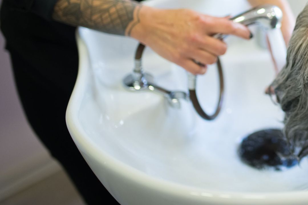 Hände waschen einer Kundin am Becken die Haare